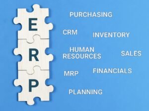 Enterprise Resource Planning concept. Text ERP with jigsaw puzzle pieces on blue background.